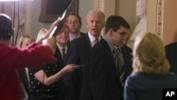 Vice President Joe Biden, center, with Majority Leader Harry Reid of Nevada, and Majority Whip Dick Durbin of Illinois, head to a Senate Democratic caucus meeting about the fiscal cliff, on Capitol Hill Monday, Dec. 31, 2012 in Washington.