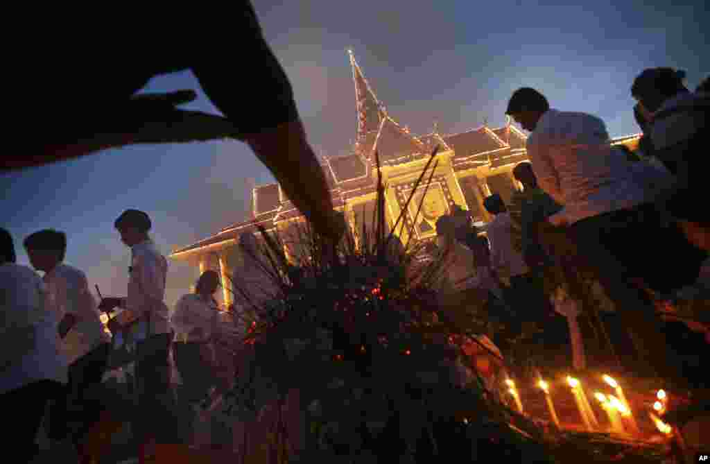 Mourners burn incense and offer prayers at the Royal Palace displaying a portrait of their former King Norodom Sihanouk in Phnom Penh, Cambodia, Oct. 17, 2012.