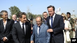 From left: French philosopher Bernard-Henri-Levy, France's President Nicolas Sarkozy, NTC PM Mahmoud Jibril, and Britain's PM David Cameron arrive at the Tripoli Medical Center, Sep 15, 2011.