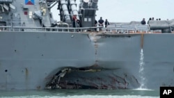 FILE - damage is visible as the guided-missile destroyer USS John S. McCain steers towards Changi naval base in Singapore following a collision with the merchant vessel Alnic MC. 