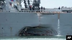 FILE - Damage is visible as the guided-missile destroyer USS John S. McCain steers toward Changi naval base in Singapore following a collision with the merchant vessel Alnic MC.