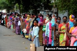 FILE - Women stand in a queue as they wait to receive groceries donated by Institute of the Sisters of Charity to the recent flood affected victims from slum areas in Secunderabad, the twin city of Hyderabad, Nov. 12, 2020.