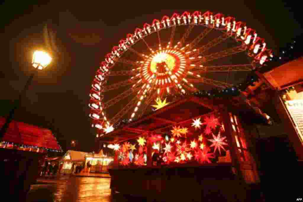 A vendor for Christmas stars waits for customers at the Christmas market on the Alexanderplatz in Berlin on Monday, Nov. 22, 2010. The Christmas markets in Berlin open on Monday for the Christmas season. (AP Photo/Markus Schreiber)