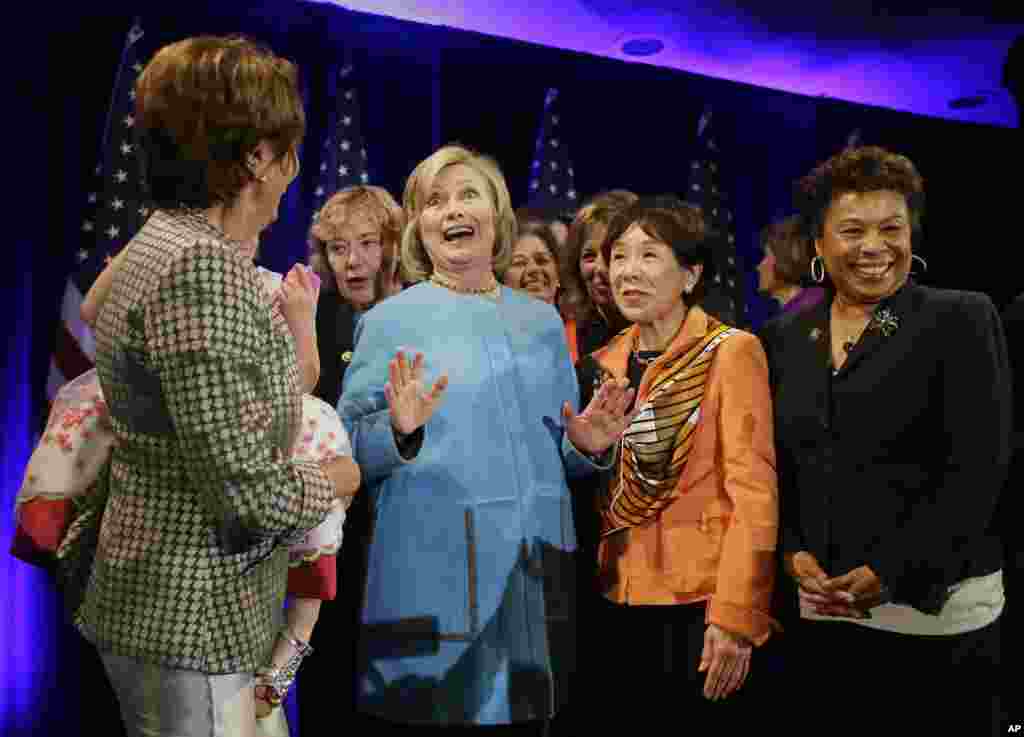 Former U.S. Secretary of State Hillary Rodham Clinton, center, gathers with legislators for a photo after speaking at a fundraiser for Democratic congressional candidates in San Francisco, Oct. 20, 2014.