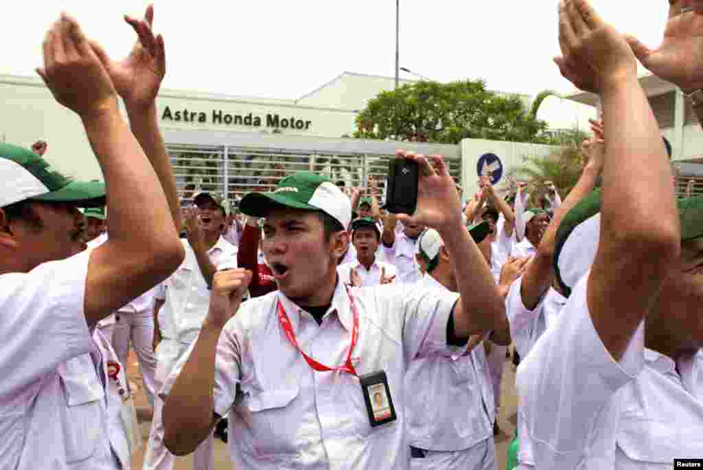 Para pekerja meneriakkan slogan-slogan di depan pabrik Astra Honda Motor di daerah industri Karawang, Jawa Barat. 