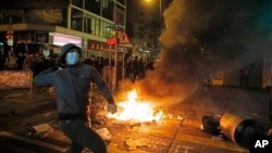 A rioter tries to throw bricks at police in Mong Kok district of Hong Kong, Feb. 9, 2016.