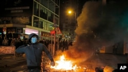 FILE - A rioter tries to throw bricks at police in the Mong Kok district of Hong Kong, Feb. 9, 2016.