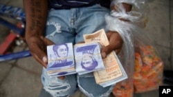 Un vendedor callejero muestra 9 millones de bolívares que ganó vendiendo dulces, en Caracas, Venezuela, el jueves 17 de junio de 2021.

