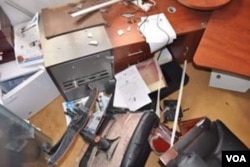 Ahmed shows this picture on his cellphone of his former office, smashed by men hunting him for revenge in a lawless part of Libya, July 8, 2016. (Photo: H. Murdock / VOA)