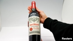 A woman holds a bottle of Petrus 2000, a space-aged bottle of fine French wine part of a case of Bordeaux that was literally matured in Earth orbit for 14 months. (REUTERS/Gonzalo Fuentes)