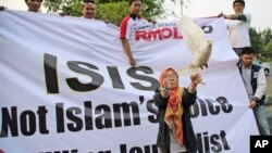 FILE - A woman releases a dove as a symbol of peace during a rally against the Islamic State group in Jakarta, Indonesia, Sept. 5, 2014. 