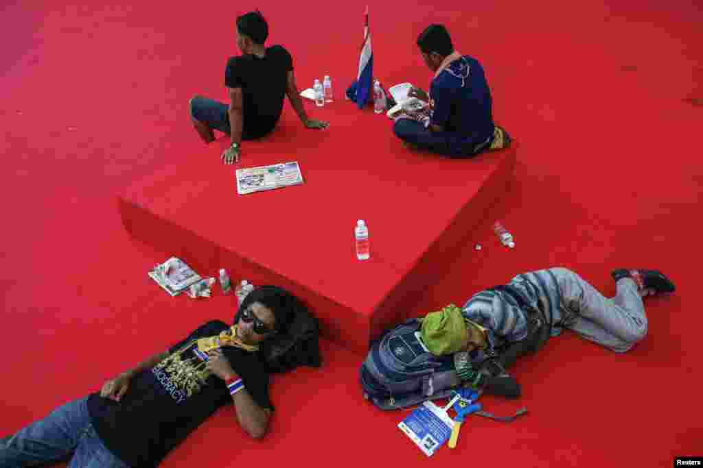 Anti-government protesters rest inside a government complex in Bangkok November 28, 2013.
