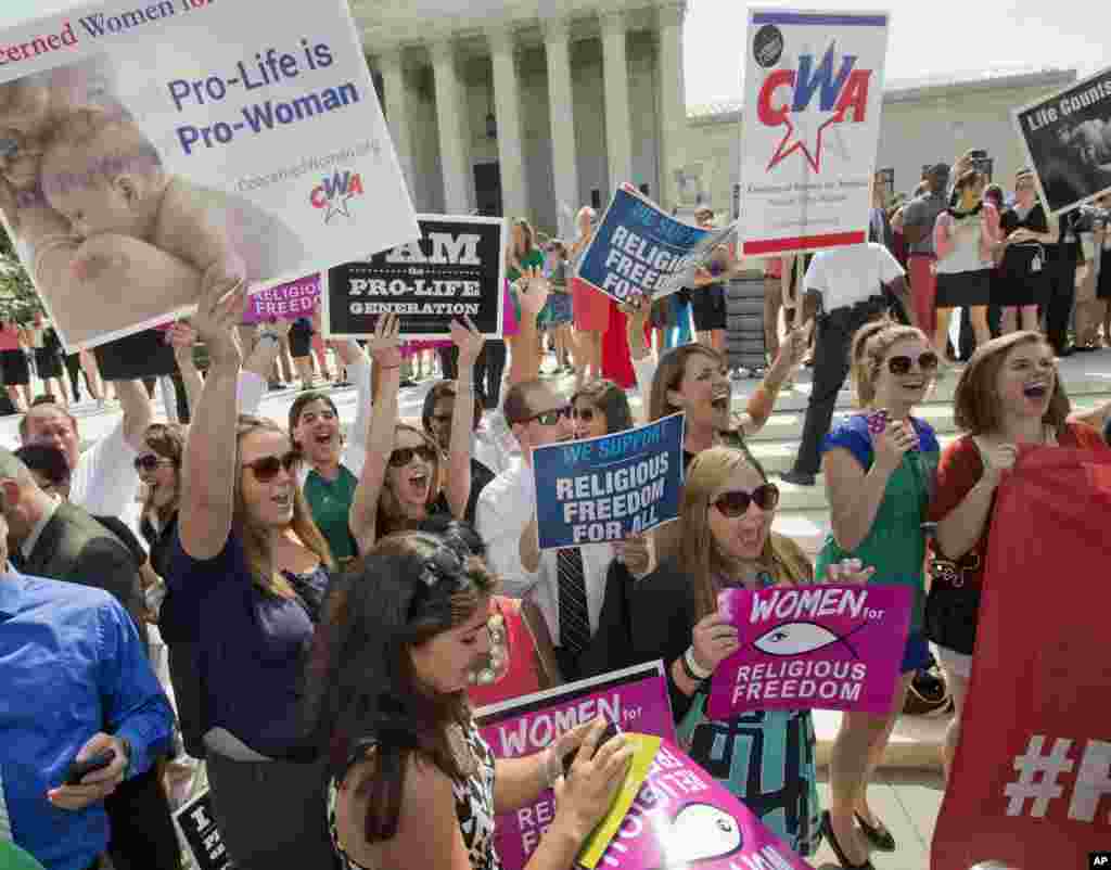 Demonstrators react to hearing the Supreme Court decision on the Hobby Lobby case outside the Supreme Court, in Washington, June 30, 2014.