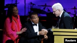 Honoree Steve Martin (R) accepts his award from Muhammed and Lonnie Ali at the Muhammad Ali Celebrity Fight Night Awards XIX in Phoenix, Arizona March 23, 2013. The charity event is held in honor of Muhammad Ali's fight to find a cure for Parkinson's dise