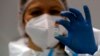 FILE - In this Tuesday, Jan. 19, 2021 file photo, a medical worker poses with a vial of the Sinopharm's COVID-19 vaccine in Belgrade, Serbia. 