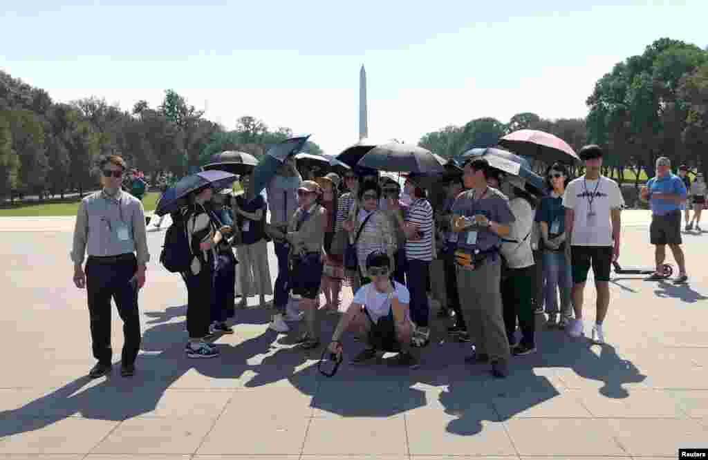 امریکہ کے دارالحکومت کا دورہ کرنے والے سیاح خود کو سورج کی تپش سے بچانے کے لیے چھتریاں ساتھ لے کر چلتے ہیں۔ &nbsp; 