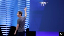 Facebook CEO Mark Zuckerberg points to a drone during his address at the F8 Facebook Developer Conference in San Francisco, April 12, 2016. Facebook said it had completed, in June 2016, a successful test flight of a drone that it hopes will help it extend internet connectivity around the world. A second test occurred May 22, 2017. 