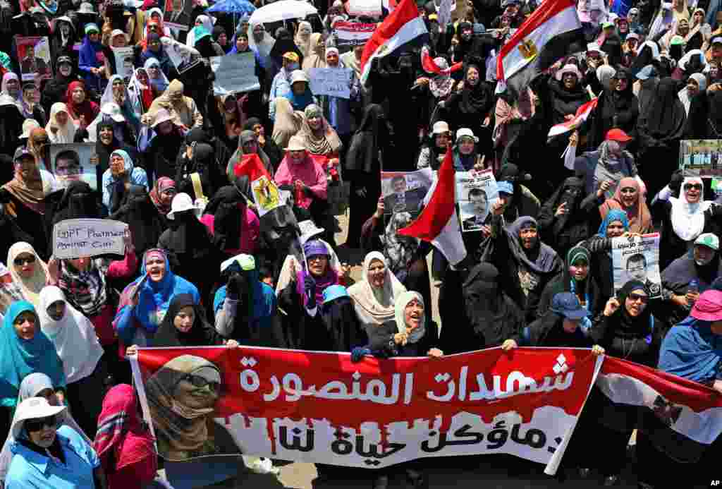 Supporters of ousted Egyptian President Mohamed Morsi carry a banner depicting a woman who was killed during a protest, outside the National Council for Human Rights in Cairo, July 21, 2013. 