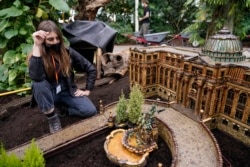 Laura Busse Dolan looks over the newest creation in the Holiday Train Show, a miniature of the LuEsther T. Mertz Library, at the New York Botanical Garden in New York, Nov. 11, 2021.