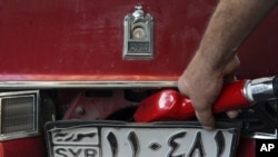 A Syrian gas station attendant fills up a car in Damascus (file photo)