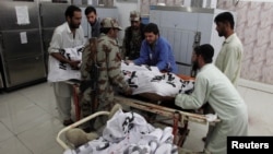 Soldiers help paramedics move the body of one of four Frontier Corps personnel killed by gunmen in Quetta, Pakistan, June 29, 2016.