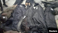 Covered dead bodies lie on the ground after Islamic State fighters killed 20 people in the village of Aqarib al-Safi, east of Hama city, Syria in this handout picture provided by SANA on May 18, 2017.