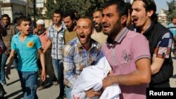 敘利亞戰機星期三襲擊了北部城市阿勒頗﹐親友將受害者屍體運走。