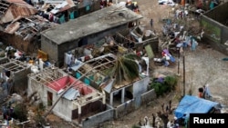 Des personnes éplorées, impuissantes, constatent les dégâts laissés par le passage de l'ouragan Matthew à Jérémie, Haïti, le 6 octobre 2016.