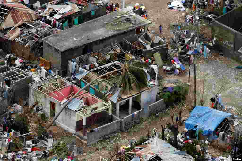 Warga di Jeremie, Haiti, berdiri di dekat rumah-rumah mereka yang hancur akibat Badai Matthew (6/10).(Reuters/Carlos Garcia Rawlins)