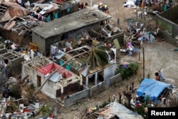 People stand next to destroyed houses after Hurricane Matthew passed Jeremie, Haiti, Oct. 6, 2016.