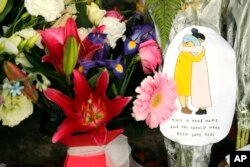 A message card is placed at a collection of flowers left at the Botanical Gardens in Christchurch, New Zealand, March 16, 2019.