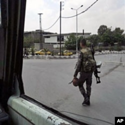 In this photo taken on a mobile phone, a Syrian soldier patrols streets in Damascus on May 8, 2011