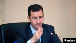 Syria's President Bashar al-Assad heads a Cabinet meeting in Damascus, in this handout photograph distributed by Syria's national news agency SANA, February 12, 2013. 