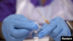 Un trabajador médico prepara una inyección con una dosis de la vacuna contra el coronavirus Astra Zeneca, en un centro de vacunación en la mezquita Baitul Futuh, en medio del brote de la enfermedad por coronavirus. [Foto de archivo]