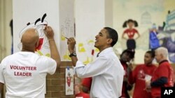 President Barack Obama helps to paint cartoon characters in a lunchroom as he observes the Martin Luther King Jr. Day holiday, 17 Jan 2011.
