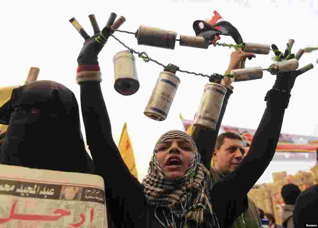 An anti-Morsi protester holds empty tear gas canisters that were shot by the riot police during a protest at Tahrir Square in Cairo November 27.