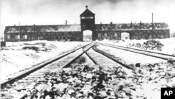 FILE- This February/March 1945 photo shows the entry to the concentration camp Auschwitz-Birkenau in Poland, with snow-covered rail tracks leading to the camp.