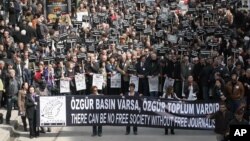 Hundreds of Turkish journalists, some holding photos of recently jailed journalists, march to protest the detention of journalists in an alleged coup plot and demand reforms to Turkey's media laws, in Ankara, Turkey, Mar. 19, 2011.