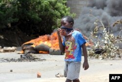 Un enfant se couvre la bouche pour se protéger de la fumée, Lusaka, Zambie, le 12 janvier 2018