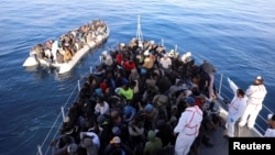 Migrants are seen in a rubber dinghy as they are met by the Libyan coast guard in the Mediterranean Sea off the coast of Libya, Jan. 15, 2018. 