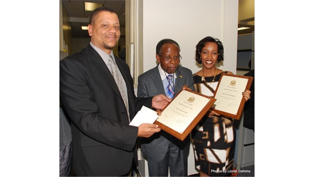 Nyakwigendera Janvier Ntahomvukiye (Hagati kw'Ifoto), Ari kumwe na bamwe mu bo bakoranye ku munsi aja mu karuhuko k'izabukuru. Kuri iyo foto, afise za certificat zamushimira ku vyo yakoze