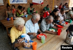 Venezuelans have a meal at a dining facility organized by the Catholic church, in Cucuta, Colombia, Feb. 21, 2018.