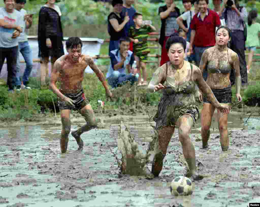 People take part in a mud football match during a festival for celebrating harvest in a village in Jinhua, Zhejiang Province, China.