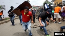 Demonstrators take cover as police fire at them during a protest against the government of Nicaraguan President Daniel Ortega in Masaya, Nicaragua, June 19, 2018. 