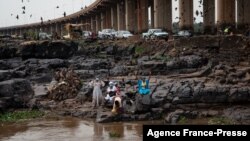 FILE - Women perform a traditional ceremony on the shore of the Niger river, next to the 'Third Bridge', in Bamak, Mali, July 2, 2021. 