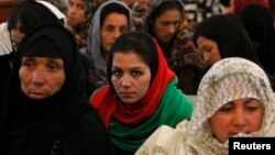 Women listen to a speech by Afghanistan's President Hamid Karzai during a district assembly gathering, in Kabul, May 30, 2013. 