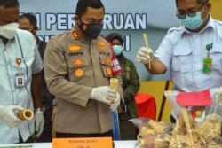 Polisi menunjukkan barang bukti berupa pipa rokok, ornamen pakaian adat dan barang koleksi dari gading gajah, di Lhokseumawe, Provinsi Aceh, 19 Agustus 2021. (AFP)