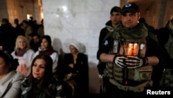 Warga Kristen Irak menghadiri Misa Malam Natal di gereja Mar Shimoni di Bartella, Irak (24/12). (Reuters/Ammar Awad)