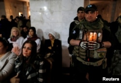 Iraqi Christians attend a Mass on Christmas Eve at the Mar Shimoni church in Bartella, Iraq, Dec. 24, 2016. Iraqi forces freed Bartella in October from IS control, but residents have not been able to return. They were bused in for the service.