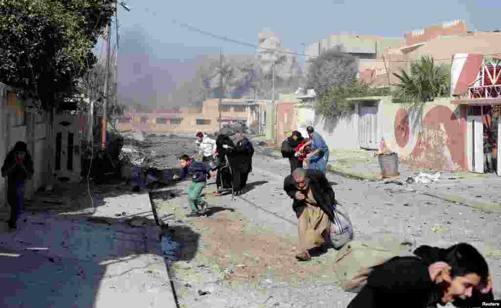 People run in panic after a coalition airstrike hit Islamic State fighter positions in the Tahrir neighborhood of Mosul, Iraq.